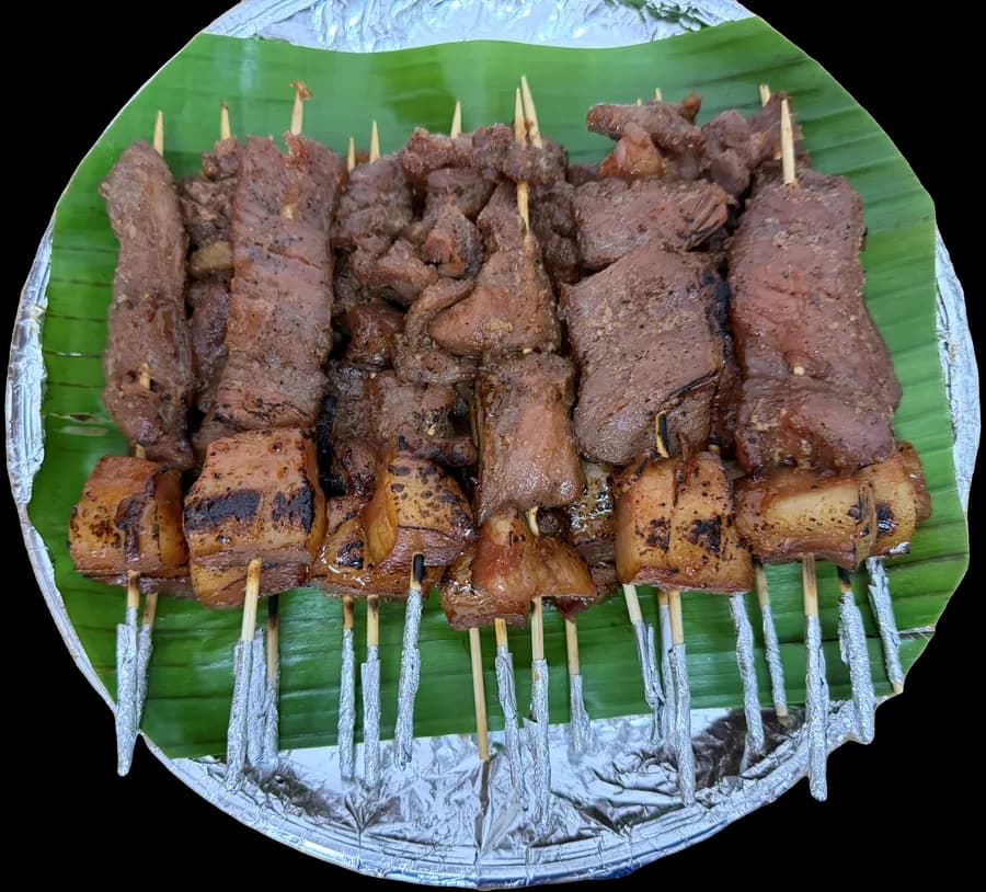 BBQ skewers arranged on banana leaf